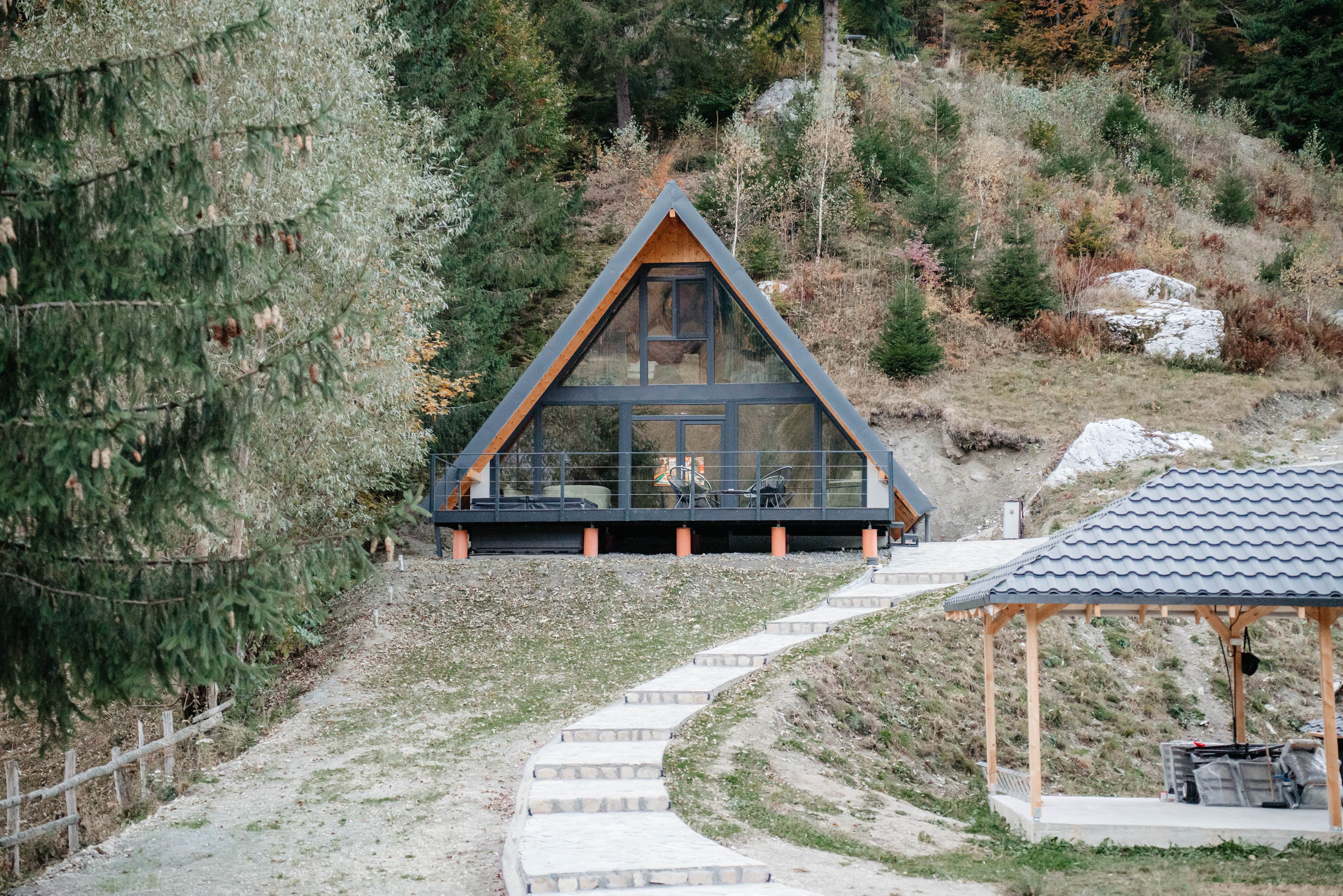 A-frame cabin with glowing windows among tall trees